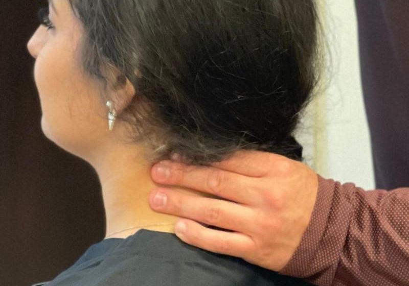 Photo of a woman receiving a chiropractic adjustment to her neck